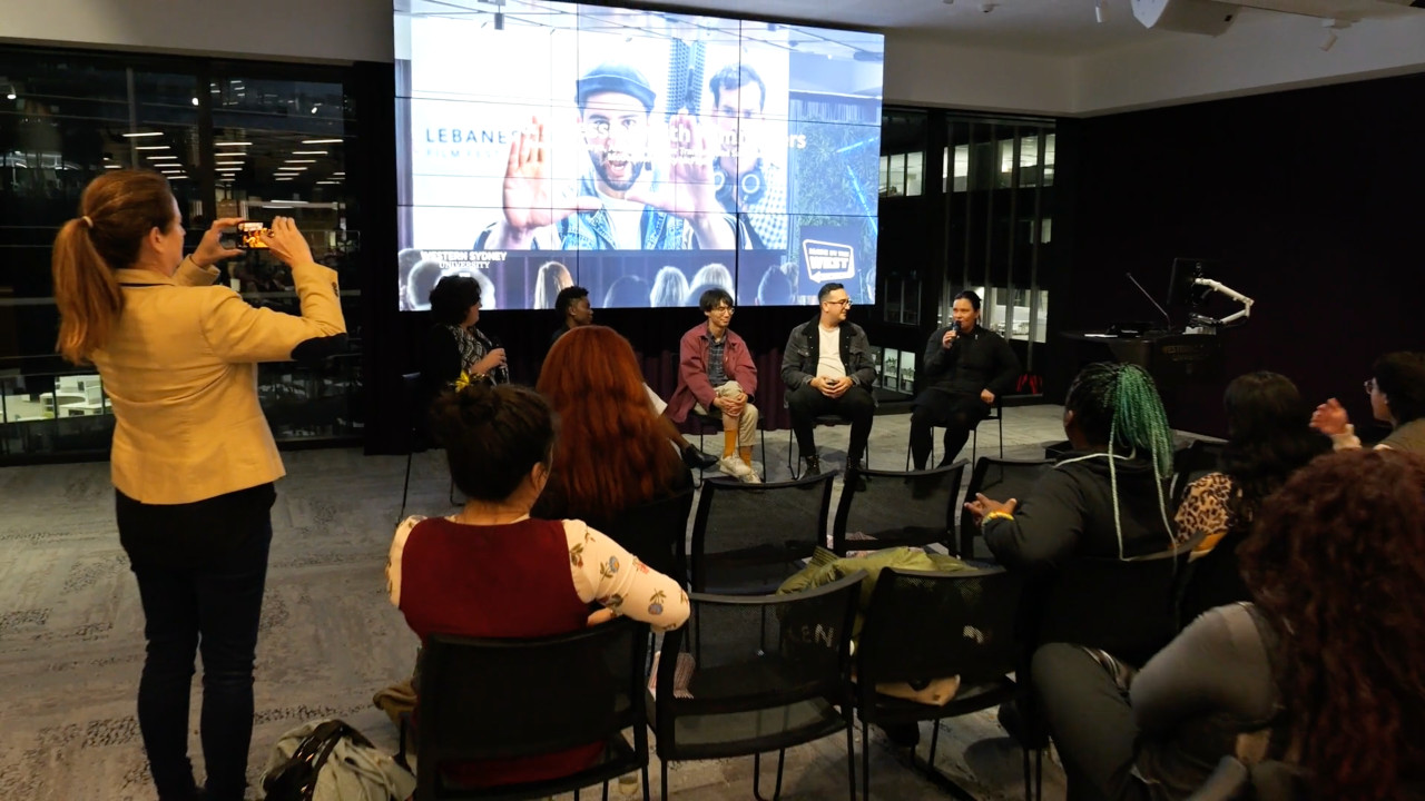 Digital screen shows local films and audience watching